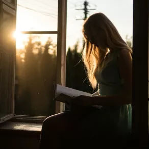 فتاة تقرأ عند مغيب الشمس