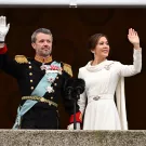 الملكة ماري ترتدي فستانا أبيض اللون وتقف بجوار زوجها على شرفة القصر لتحية الجماهير
