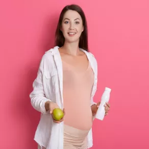 صورة لامرأة حامل تحمل طعاماً