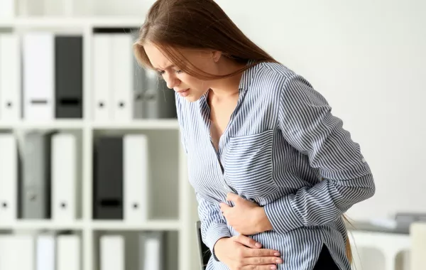 امرأة تعاني من ألم شديد في البطن بسبب التسمم الغذائي