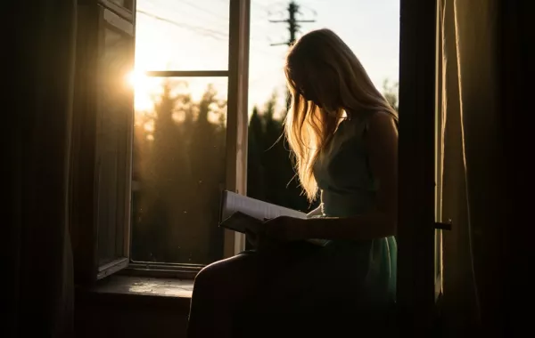 فتاة تقرأ عند مغيب الشمس