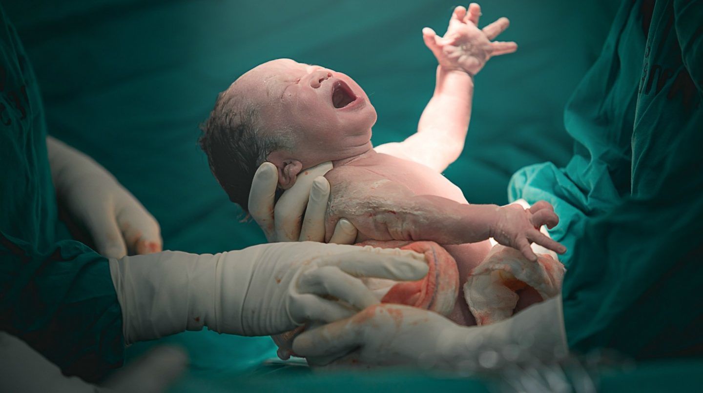 doctor-nurse-pulling-new-born-baby-vbac-ss-feature-1440x806.jpg