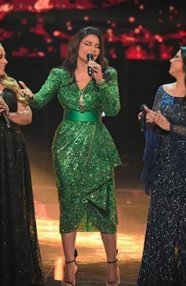 فستان أخضر أبرز نحافة خصر أحلام من خلال الحزام العريض