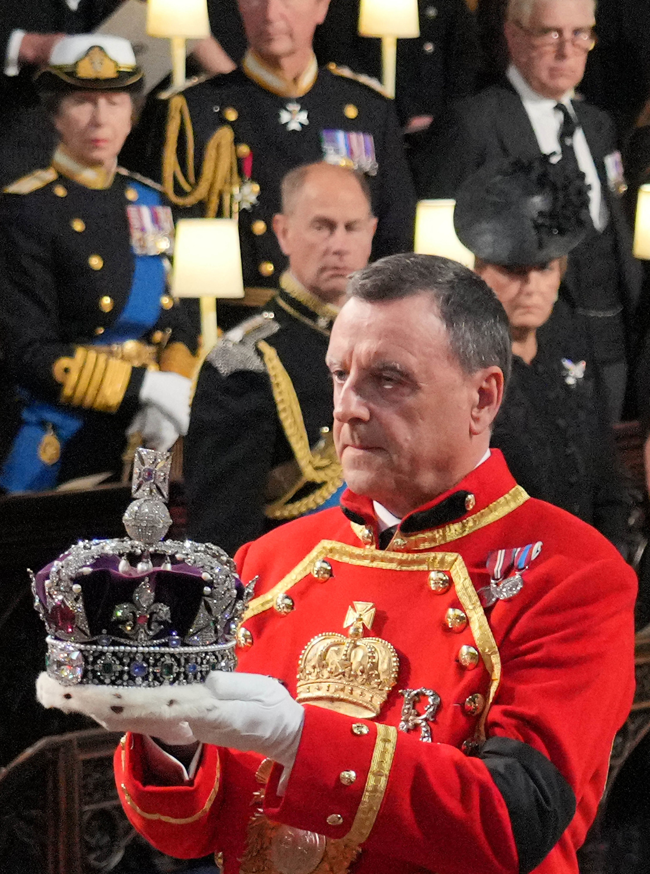 The coffin of Queen Elizabeth II, adorned with a Royal Standard and the Imperial State Crown is pictured during a procession from Buckingham Palace to the Palace of Westminster, in London on September 14, 2022. Queen Elizabeth II will lie in state in Westminster Hall inside the Palace of Westminster, from Wednesday until a few hours before her funeral on Monday, with huge queues expected to file past her coffin to pay their respects.MARKO DJURICA / POOL / AFP