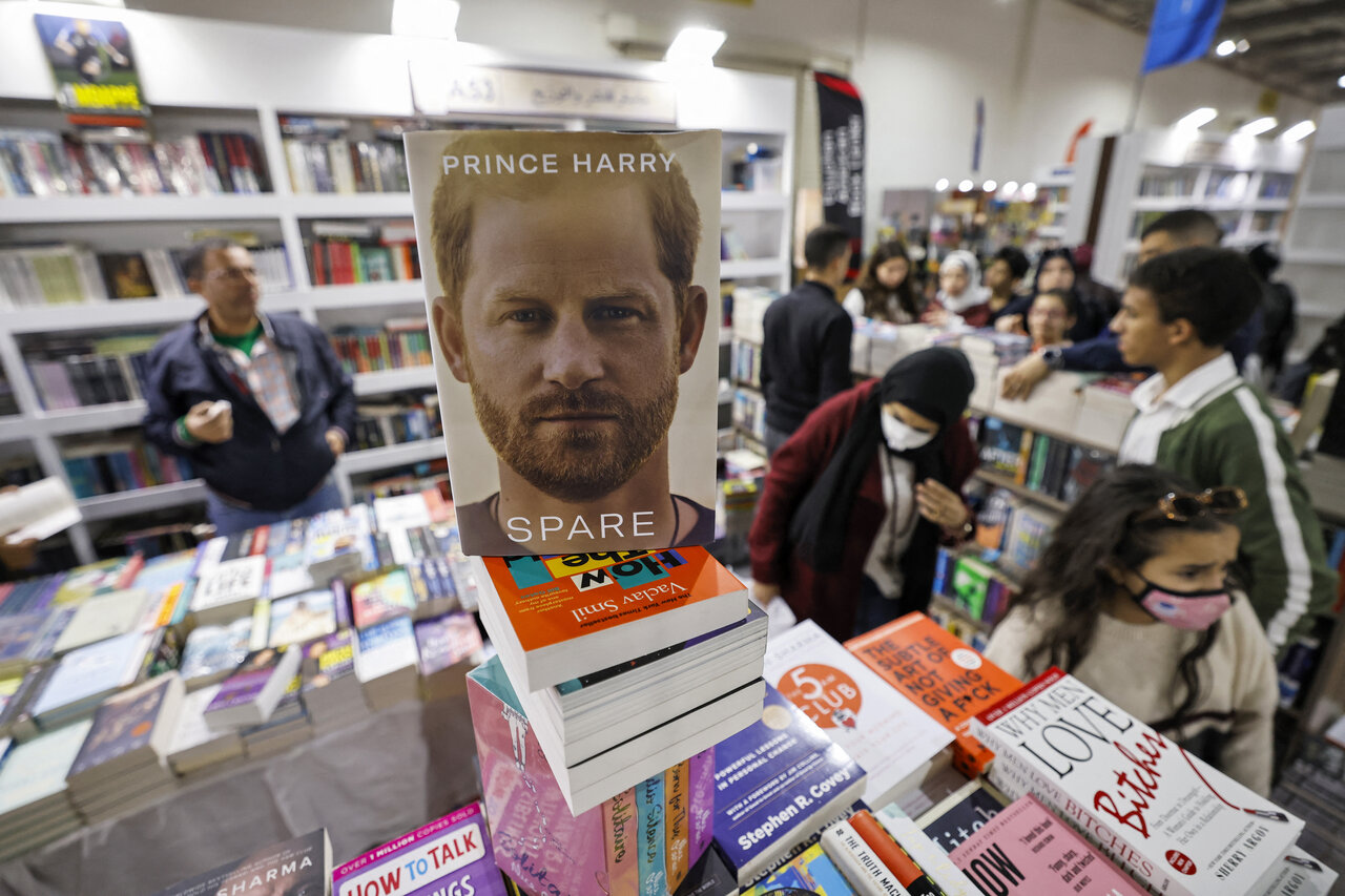 People browse books behind a copy of "Spare" by Britain's Prince Harry at a stall at the 54th Cairo International Book Fair in Egypt's capital on January 29, 2023. Khaled DESOUKI / AFP
