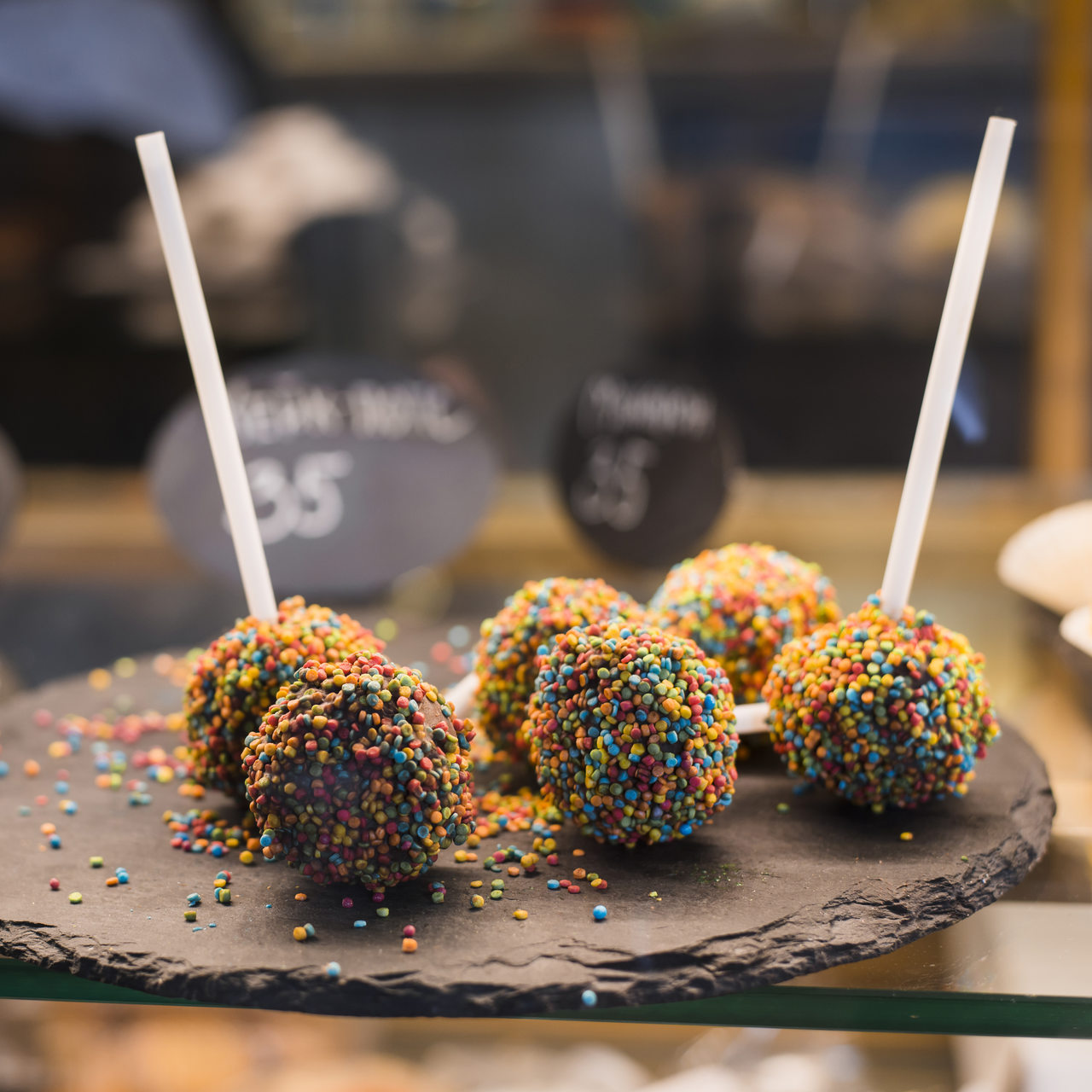 festive-chocolate-cake-pops-with-candy-sprinkles-displayed-coffee-shop_easy-resize.com.jpg