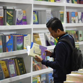 An young man checks a book at the grounds of the 50th Cairo International Book Fair which was opened in the New Cairo suburb of the Egyptian capital on January 23, 2019. MOHAMED EL-SHAHED / AFP