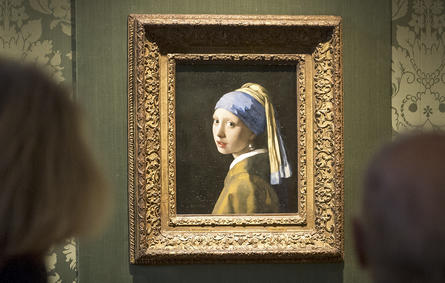 Visitors looks at the Johannes Vermeer's painting "Girl with a Pearl Earring" at the Mauritshuis museum in The Hague, 27 October 2022. - Dutch police arrested three people after climate activists targeted Johannes Vermeer's painting "Girl with a Pearl Earring". (Photo by Lex van Lieshout / ANP / AFP) / Netherlands OUT