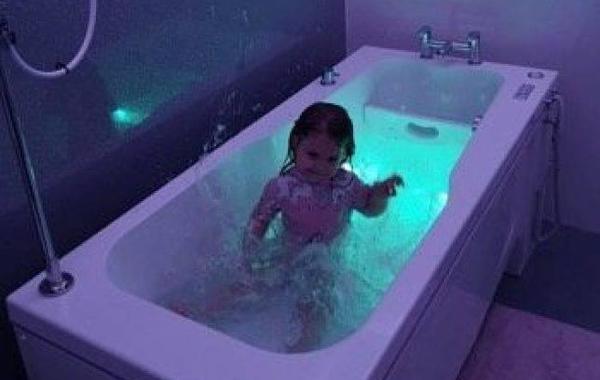 بالصور.. طفلة مصابة بمتلازمة نادرة لا تجد راحتها إلا في حوض الاستحمام