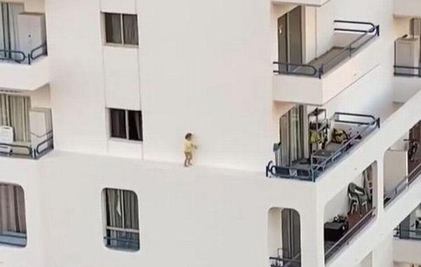 شاهد... طفلة تخرج من نافذة في الدور الخامس وتمشي على حافة المبنى