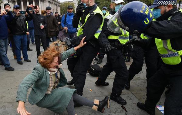 الشرطة البريطانية تعتدي على سيدة وسط المتظاهرين ضد الإغلاق