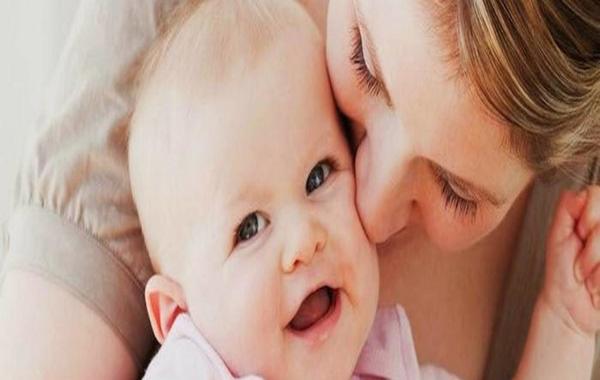صورة لرضيع يبتسم بعد تقبيل والدته له