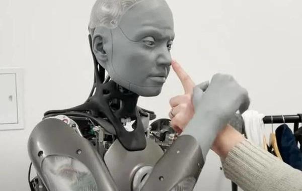 صورة الروبوت أميكا يمسك يد باحث