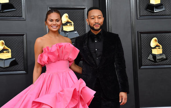 US model Chrissy Teigen (L) and US singer-songwriter John Legend arrive for the 64th Annual Grammy Awards at the MGM Grand Garden Arena in Las Vegas on April 3, 2022. ANGELA WEISS / AFP