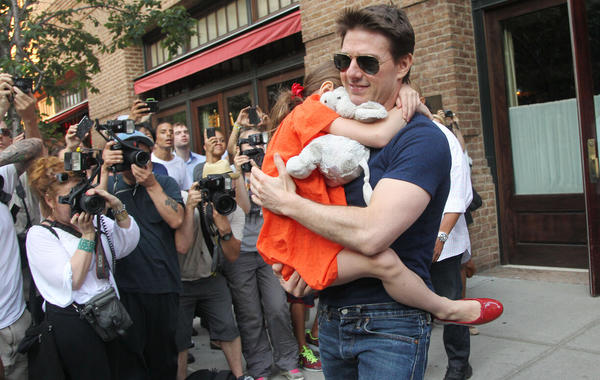 Tom Cruise leaves his hotel carrying daughter Suri for her gymnastics class on July 17, 2012 in New York, NY.  MEHDI TAAMALLAH / AFP
