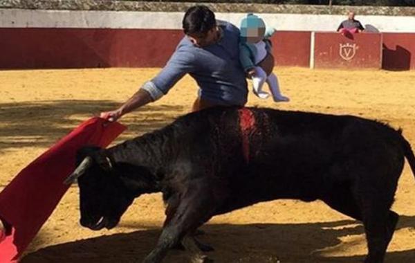 بالصورة: إسباني يصارع الثيران وهو يحمل طفلته الرضيعة